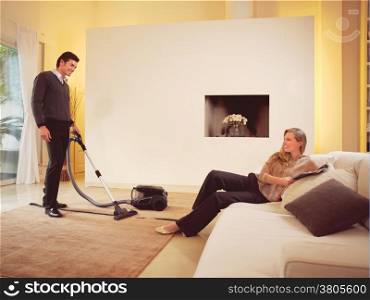 happy man cleaning the carpets in house an woman