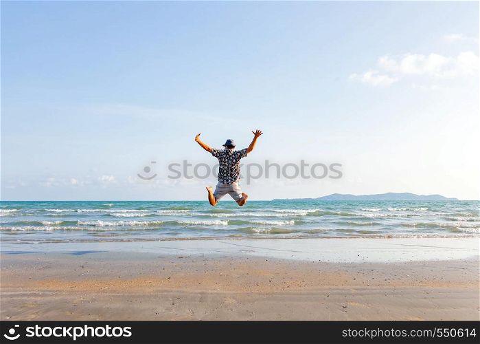happy man freedom jump ocean sea scape background on beach. Backyard of jumping man on landscape summer beach evening