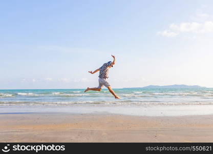 happy man freedom jump ocean sea scape background on beach. Backyard of jumping man on landscape summer beach evening