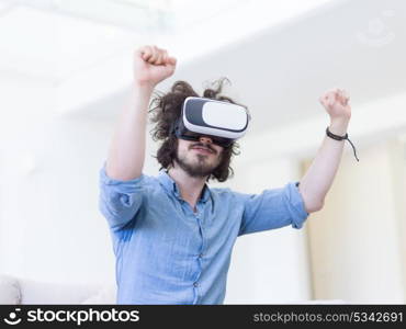 happy man getting experience using VR-headset glasses of virtual reality at home