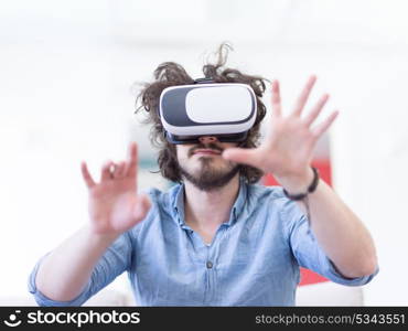 happy man getting experience using VR-headset glasses of virtual reality at home