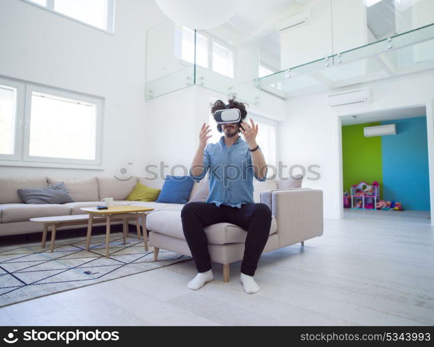 happy man getting experience using VR-headset glasses of virtual reality at home