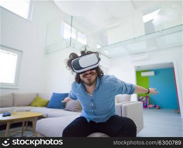 happy man getting experience using VR-headset glasses of virtual reality at home