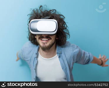 Happy man getting experience using VR headset glasses of virtual reality, isolated on blue background