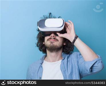 Happy man getting experience using VR headset glasses of virtual reality, isolated on blue background