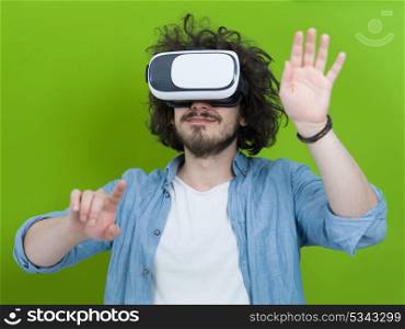 Happy man getting experience using VR headset glasses of virtual reality, isolated on green background
