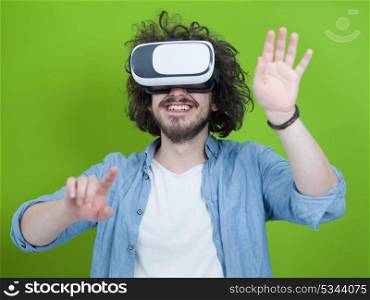 Happy man getting experience using VR headset glasses of virtual reality, isolated on green background