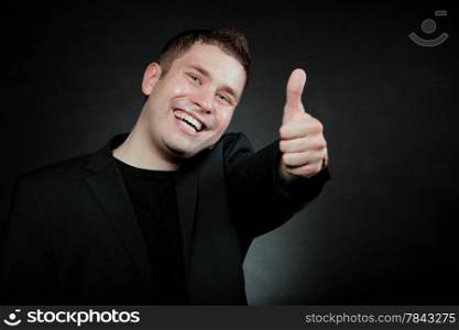 Happy man giving thumb up gesturing the all right symbol , ok sign black background