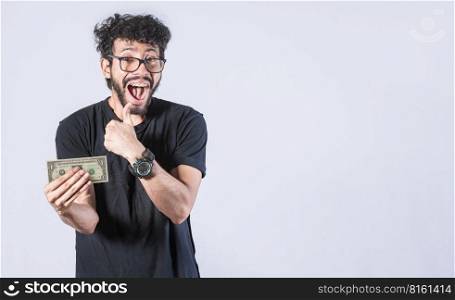 Happy man holding banknote in his hand, man with a banknote in his hand with thumb up, saving man concept, guy with money isolated