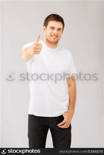 happy man in blank white t-shirt showing thumbs up