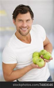 happy man is standing and holding apples in hands