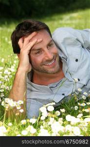 Happy man laid in a field