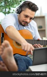 happy man learning to play guitar chords correctly