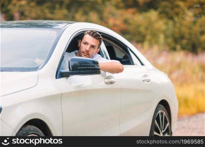 Happy man on his auto trip. Young man tourist enjoying on summer vacation