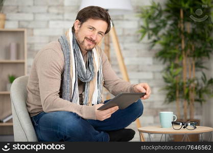 happy man on sofa with digital tablet