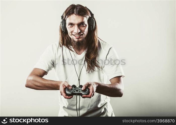 Happy man playing games. Playing games. Young smiling cheerful man play on console xbox playstation. Guy with pad joystick.