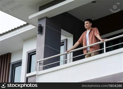 happy man relaxing and looking from balcony of his home