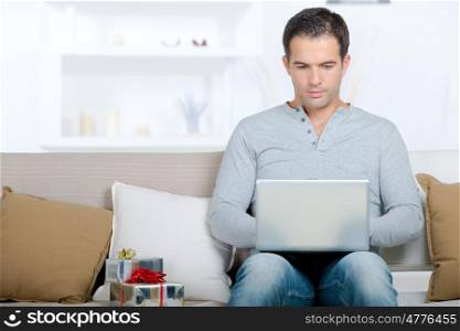happy man sitting with laptop computer on sofa