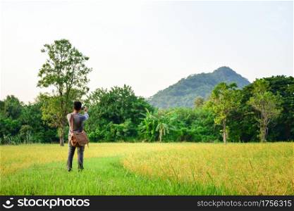 Happy man taking Photo of rice field Natural background.