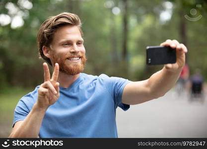 happy man taking selfie and hiking in forest