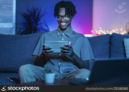 happy man using his tablet home couch