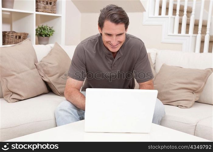 Happy Man Using Laptop Computer At Home