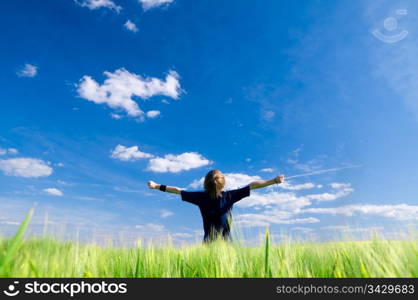 Happy man with arms up on summer field