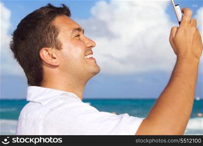 happy man with cell phone on the beach