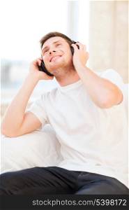 happy man with headphones listening to music at home