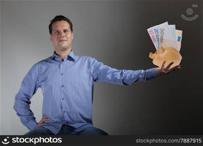 happy man with piggy bank and euro banknote gray background
