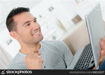 happy man working with laptop indoors