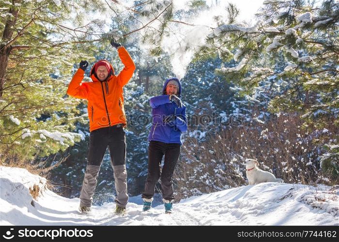 happy married couple having fun in the winter snow-covered forest