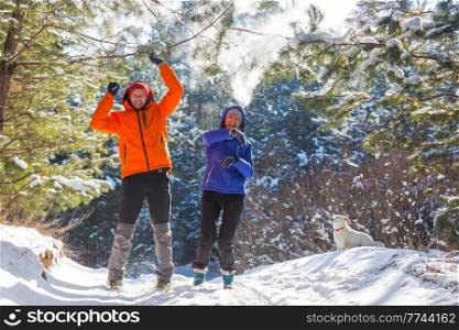 happy married couple having fun in the winter snow-covered forest