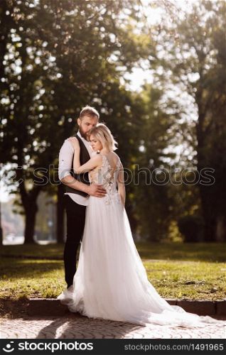 Happy married couple in simple wedding dresses. Wedding couple. Stylish newlywed couple. Stylish white dress on the bride. Marriage concept. Happy married couple in simple wedding dresses. Wedding couple. Stylish newlywed couple. Stylish white dress on the bride. Marriage concept.