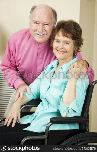 Happy mature couple in love. The wife is in a wheelchair.