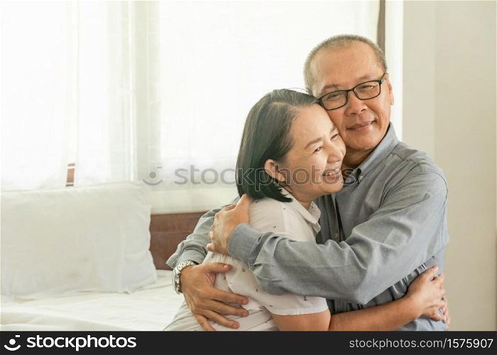 Happy Mature couple romantic flirting and hugging on a comfortable bed or sofa at home in the morning. Retirement, Older Lover and family concept.Copy Space