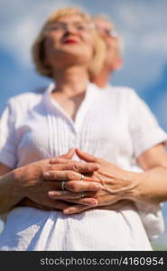 Happy mature couple - senior people (man and woman) already retired - looking to the blue sky in summer