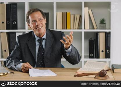 happy mature lawyer sitting court room gesturing