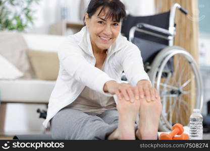 happy mature woman stretching on a mat