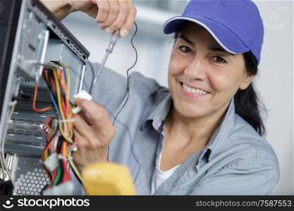 happy mature woman testing voltage of a pc