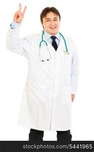 Happy medical doctor showing victory gesture isolated on white&#xA;
