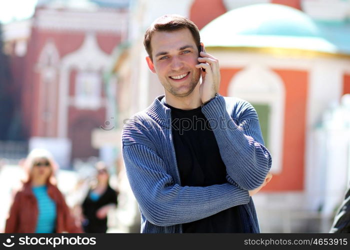 happy men calling by phone in summer street