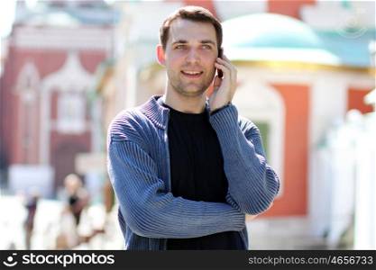happy men calling by phone in summer street