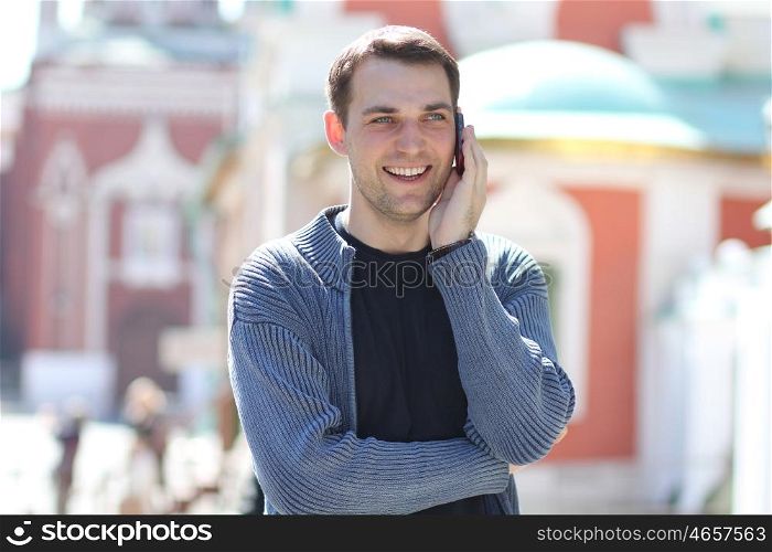 happy men calling by phone in summer street