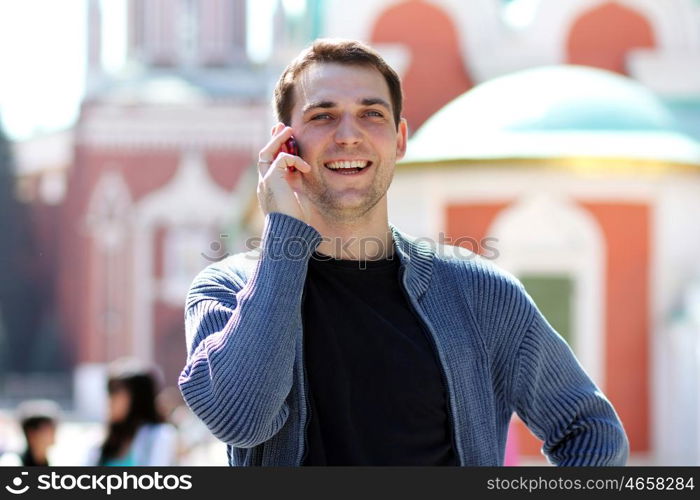 happy men calling by phone in summer street