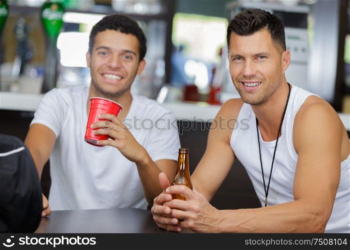 happy men drinking smoothies after sport