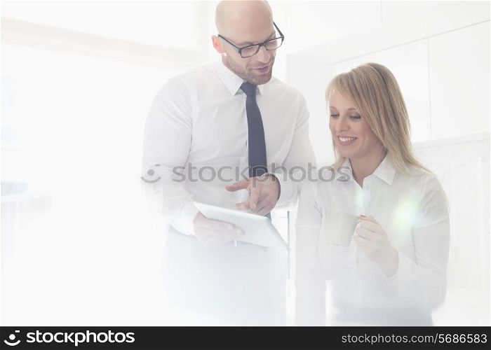 Happy mid adult business couple using tablet PC at home