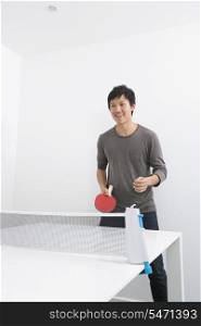 Happy mid adult man playing ping pong