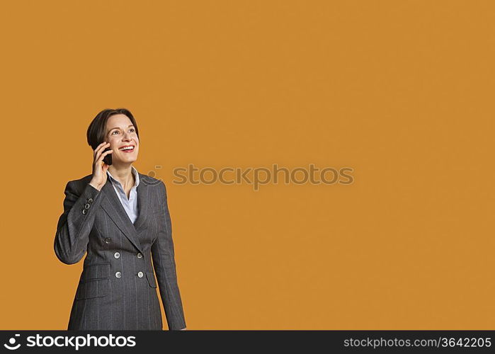 Happy mid adult woman talking on mobile phone