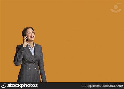 Happy mid adult woman talking on mobile phone